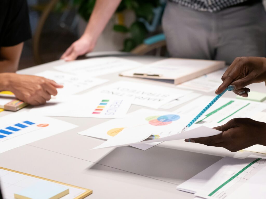 Team analyzing documents and charts during a collaborative office meeting.