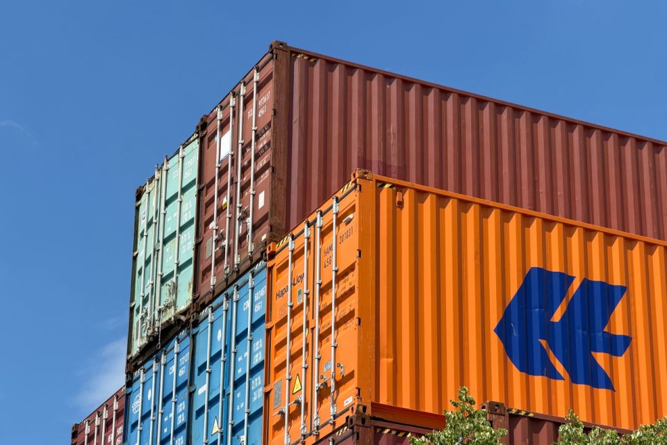 Colorful shipping containers stacked in an outdoor storage area in Germany.