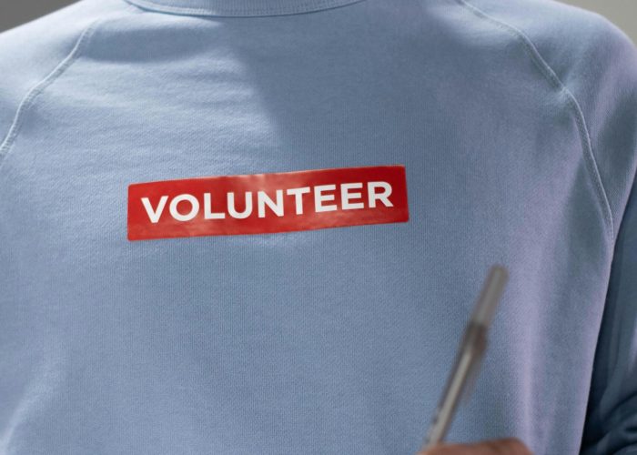 Close-up of a volunteer writing notes indoors, emphasizing community service.