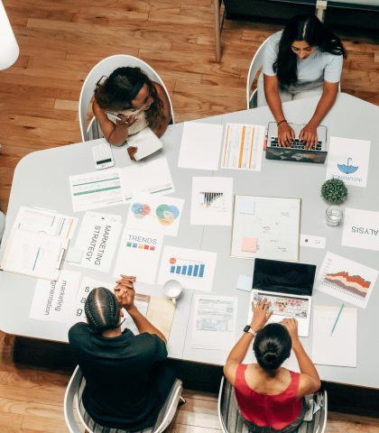 A diverse group working on marketing strategies with charts and laptops in an office setting.