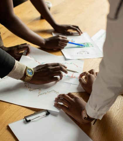 A diverse group discusses business documents in an office environment.